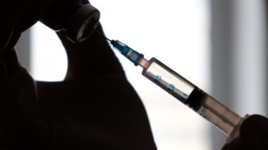 doktor bir enjeksiyon yapmak için şırınga ilaç alır