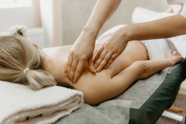 Masör sırt masajı için genç kadının işi.