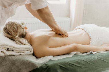 Masör sırt masajı için genç kadının işi.