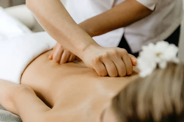 Massaggiatore facendo massaggio alla schiena per giovane donna . — Foto Stock