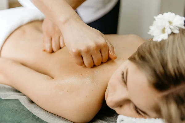 Massagista fazendo massagem nas costas para a mulher jovem . — Fotografia de Stock