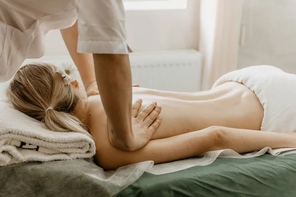 Massagista fazendo massagem nas costas para a mulher jovem . — Fotografia de Stock