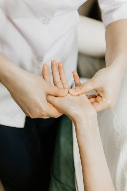 Masör profesyonel yapar el masaj için genç kadın.