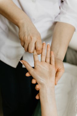 Masör profesyonel yapar el masaj için genç kadın.