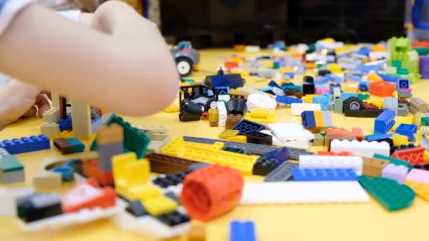Niños pequeños juegan constructor en la mesa — Vídeo de stock