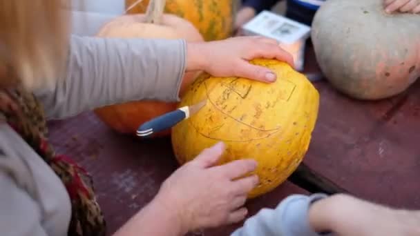 Tallar una calabaza para la fiesta de Halloween. Preparación para las vacaciones. Formación familiar . — Vídeo de stock