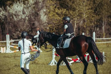 Küçük bir kız ata binmeyi öğreniyor..