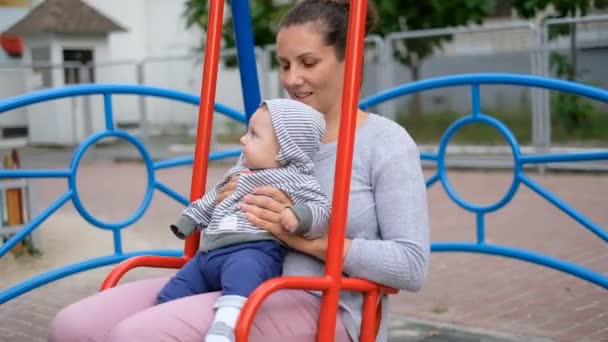 Mãe Com Bebê Está Montando Balanço Playground Andando Com Bebê — Vídeo de Stock