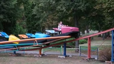 Neşeli bir çocukluk. Anne ve küçük oğlu lunaparkta eğleniyor. Aile eğlencesi. Annesiyle birlikte oğlanın biniciliğini yapıyor..