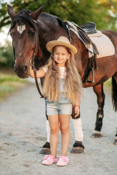 L'amitié d'un enfant avec un cheval. Traiter l'autisme avec un cheval. Interaction d'une fille autiste et d'un cheval. Marcher un enfant avec un cheval à l'automne. — Photo