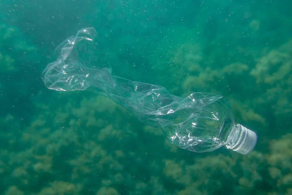 Okyanusun dibindeki plastik şişe. Gezegen kirliliği kavramı.