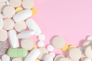 Pembe arka planda bir sürü farklı hap. Tıp konsepti