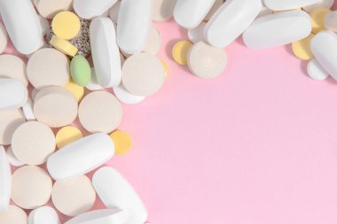 Pembe arka planda bir sürü farklı hap. Tıp konsepti