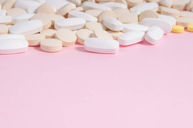 Pembe arka planda bir sürü farklı hap. Kadın sağlığı kavramı