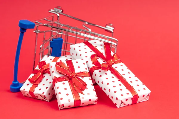 Carrito Comestibles Volcado Lleno Regalos Sobre Fondo Rojo Con Espacio — Foto de Stock