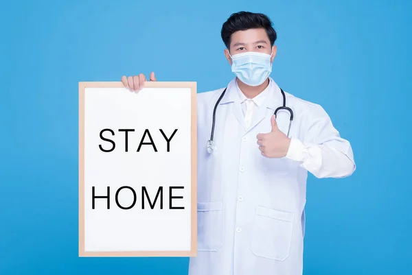 COVID-19 Quarantine lockdown country. An Asian male Doctor wearing face mask hold whiteboard \