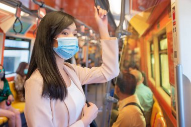 Korumalı maskeli Asyalı kadın ya da trende duran cerrahi maske.