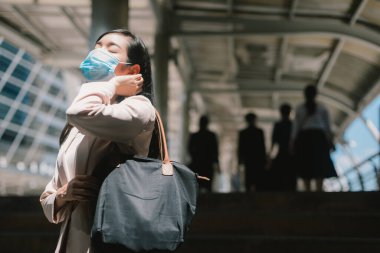 COVID-19 Pandemik Coronavirüs. Açık havada cerrahi maske takan genç bir kadını kapatın.