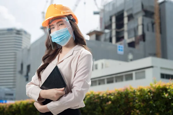Engineers having wearing protective masks to prevent dust and covid 19 disease during the inspection in construction site,Coronavirus has turned into a global emergency.