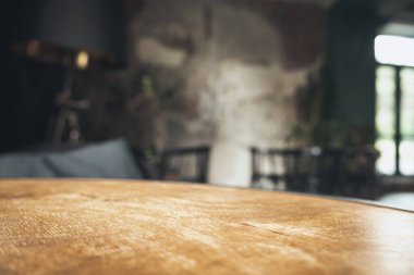 Restoranın soyut bulanık arka planının önündeki boş, siyah ahşap masa. Ürünlerinizi görüntülemek ya da montajlamak için kullanılabilir.
