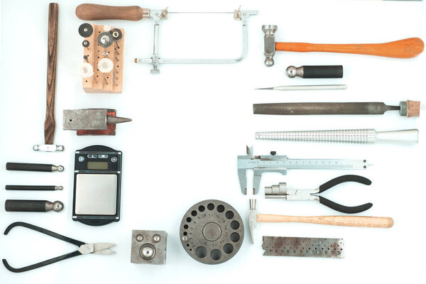 Набор ювелирных изделий. Ювелирное рабочее место на металлическом фоне с копировальным пространством для текста. Вид сверху изолирован.