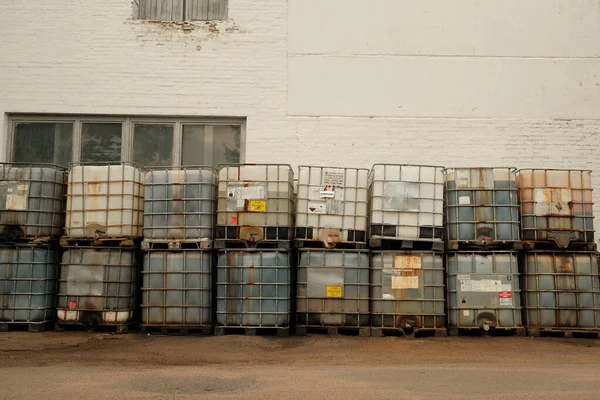Beyaz plastik fıçı. Metal çerçeveli bir palette fıçı. Kimyasal sevkiyat. Sıvılar için plastik kap.