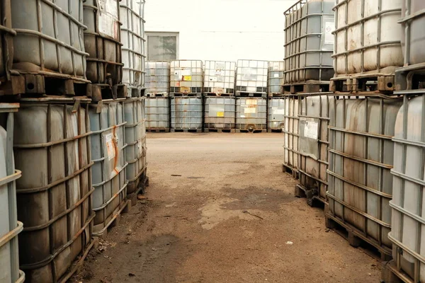 Depolama alanında metal kafesli plastik yağ kapları