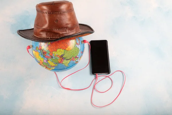 Music for the world. Globe, mobile phone and headphone isolated on blue background.