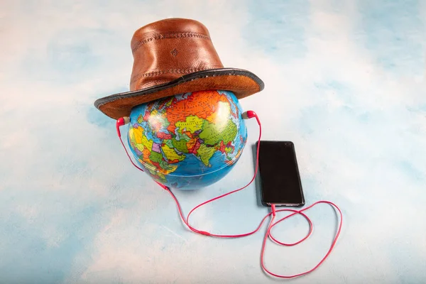 Music for the world. Globe, mobile phone and headphone isolated on blue background.