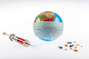 Küresel salgın. Coronavirüs salgını. Tıbbi maskeli dünya küresi. Haplı alışveriş arabası. Coronavirus karantinası. Coronavirus dünyaya yayıldı. Koruyucu ilaçlar, virüse karşı haplar..