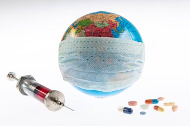 Küresel salgın. Coronavirüs salgını. Tıbbi maskeli dünya küresi. Haplı alışveriş arabası. Coronavirus karantinası. Coronavirus dünyaya yayıldı. Koruyucu ilaçlar, virüse karşı haplar..
