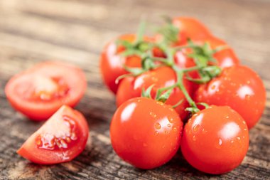 Sarmaşıktaki domatesler ahşap arka planda