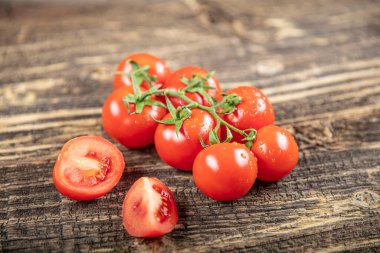 Sarmaşıktaki domatesler ahşap arka planda