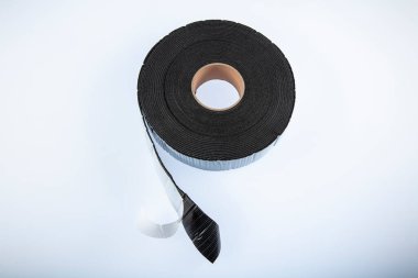 Beyaz arka planda siyah sanayi bandı. Lastik yalıtım bandı. Ses yalıtım bandı.