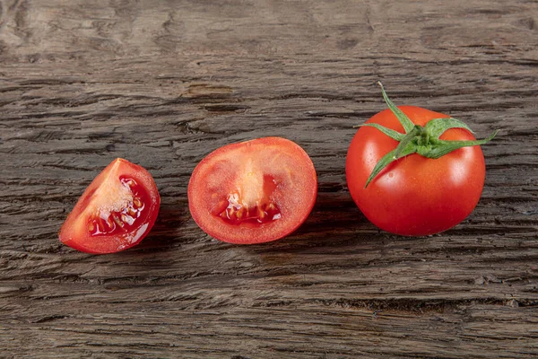 Tomato with vine on wooden background. Symbolic image. Concept for healthy nutrition. Close up.