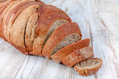 Kahverengi ekmek. Tohumlu kahverengi taze ekmek eski ahşap arka planda parçalara ayrılır. Kopyala, metin için boşluk.