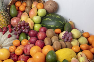 Stüdyoda çeşitli meyveler çekiliyor: mandalinalar, nar, portakal, elma, armut, üzüm, mango,... hepsi raflarda dizilmiş çekici ve göz alıcı görünüyor..