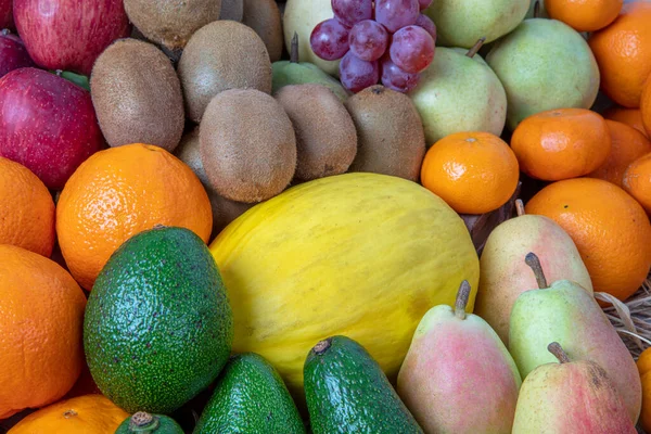 Fruit shops in the market with all kinds like: tangerines, pomegranate, orange, apple, pear, grape, mango,  ... all Arranged on shelves look attractive and eye-catching.