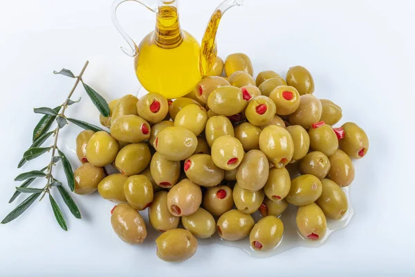 Green olives filled with red pepper. Green olives stuffed with red pepper stand on white background. Delicatessen - breakfast concept.