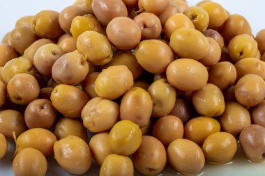 Beyaz zemin üzerinde marine edilmiş yeşil Akdeniz zeytinleri.