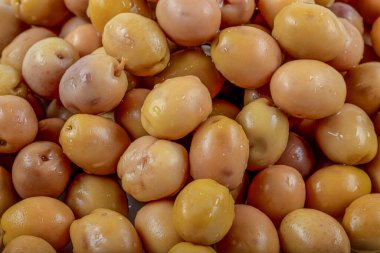 Beyaz zemin üzerinde marine edilmiş yeşil Akdeniz zeytinleri.