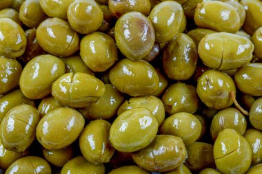 Yeşil zeytin çizilmiş. Türkçe adı: cizik yeesil zeytin. Beyaz zemin üzerinde zeytin dalı yakınında çizilmiş yeşil zeytinler.