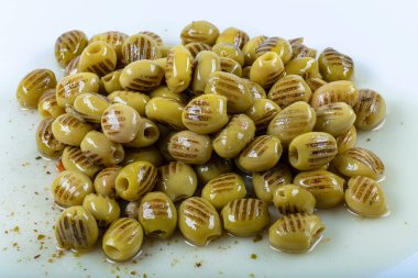 Izgara yeşil zeytin ve beyaz zemin üzerinde bir zeytin dalı.