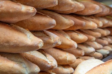 Fırındaki raflarda farklı taze ekmek var..