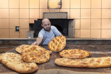  Türk pide ekmeği yapan bir fırıncı. Fırın, Türk pide ekmeği. Fırından taze Türk pidesi ekmeği alıyor. Türk Ramazan Pita üretim süreci.