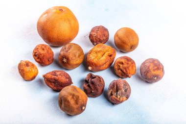 Kurutulmuş turuncu limonlar mavi renkli ahşap arka planda izole edilmiş. Bitki çayı için kuru portakal..