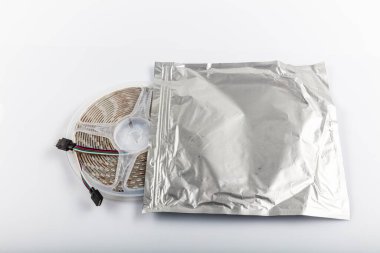 Odayı aydınlatmak için LED bantlı plastik makara. Beyaz arka planda ışık bandı..