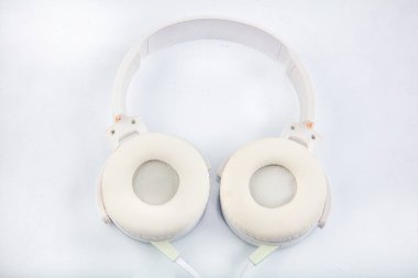 Stereo kulaklık. Beyaz arka planda fotokopi alanı olan beyaz kulaklıkların üst görüntüsü. Düz yatıyordu.