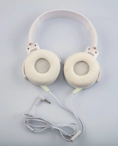 Stereo headphones. Top view of white headphones on white background with copy space. Flat lay.