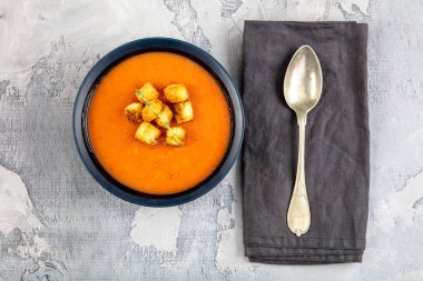 Kızarmış ekmek ve taze maydanozlu domates çorbası.